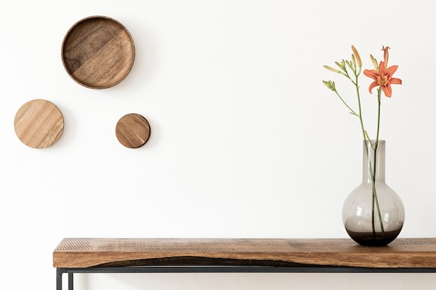 Stijlvolle compositie van woonkamer interieur met witte muur, groene planten in witte hipster ontworpen potten op de houten scandinavische console. Minimalistisch concept. Ruimte kopiëren. Sjabloon.