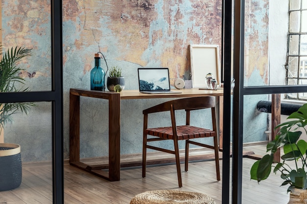 Stijlvolle en moderne compositie van creatieve werkruimte interieur met houten tafel en stoel.