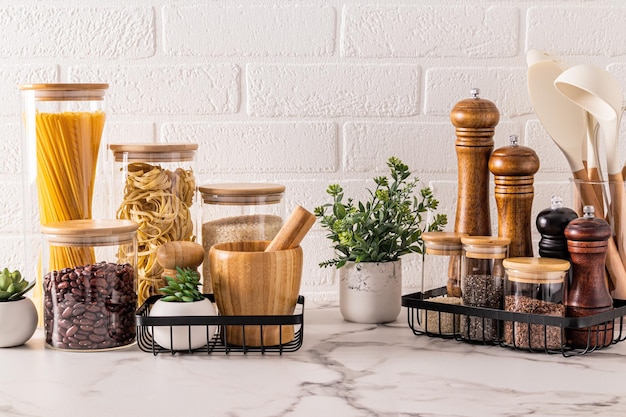 Stijlvolle handige opslag van voedsel en specerijen op het aanrecht van de keuken met potten met binnenplanten Mooie achtergrond van de keuken Front view