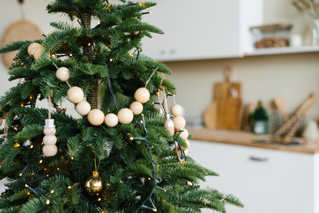 Stijlvolle houten kralen aan een kerstboom in de eetkamer van een Scandinavisch huis