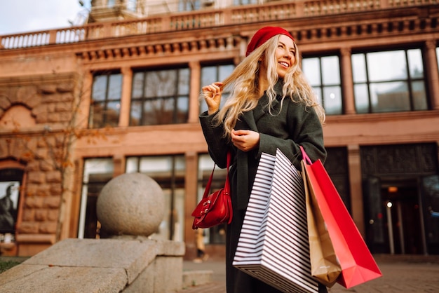 Stijlvolle jonge vrouw in trendy kleding met boodschappentassen na het winkelen Herfst winkelen