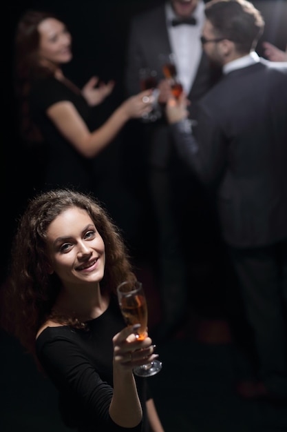 Stijlvolle jonge vrouw met glas champagne