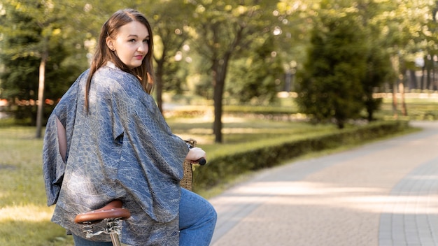 Stijlvolle jonge vrouw poseren met fiets