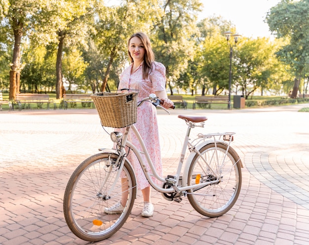 Stijlvolle jonge vrouw poseren met fiets