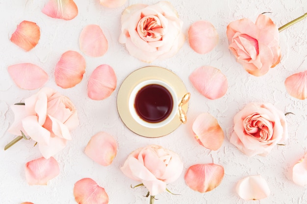 Stijlvolle kopje koffie met roze rozen bloemen en bloemblaadjes