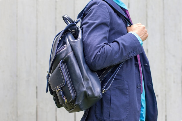 Foto stijlvolle man in blauw pak met lederen rugzak