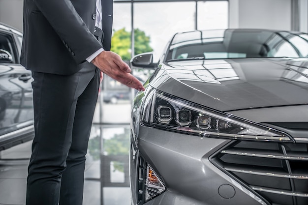 Stijlvolle man in pak bij auto showroom