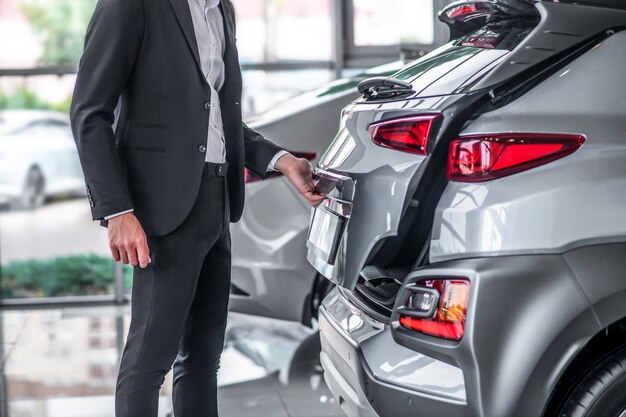 Stijlvolle man in pak bij auto showroom