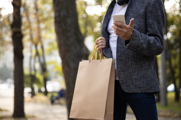 Stijlvolle man met smartphone in groen park