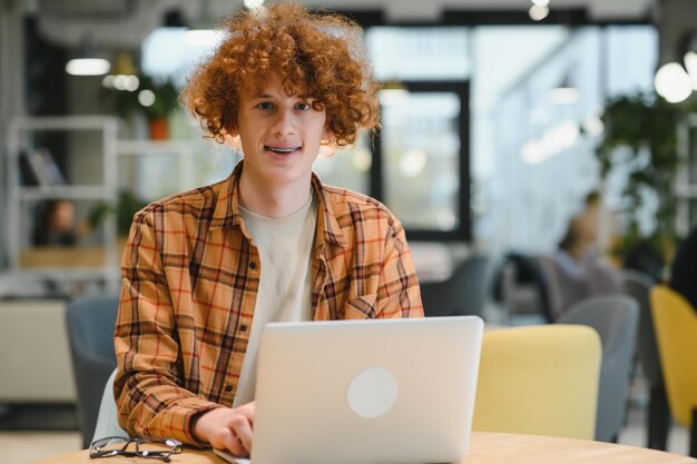 Stijlvolle mannelijke freelancer die werkt aan een nieuw opstartproject waardoor internetonderzoekers gegevens analyseren met behulp van een laptop