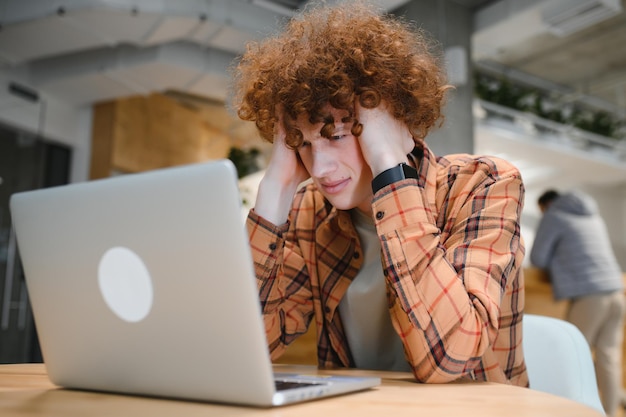 Stijlvolle mannelijke freelancer die werkt aan een nieuw opstartproject waardoor internetonderzoekers gegevens analyseren met behulp van een laptop