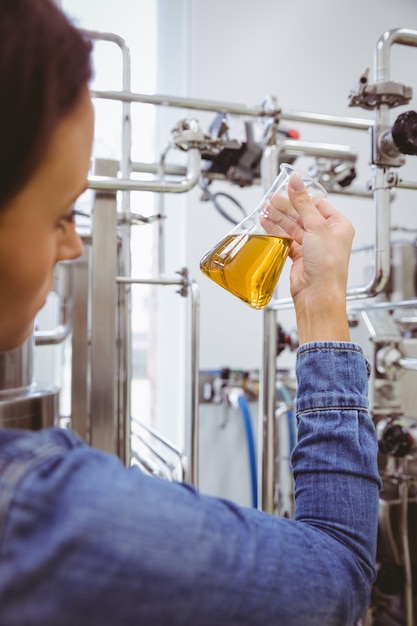 Stijlvolle meisje in denim jasje bekerglas van bier te houden