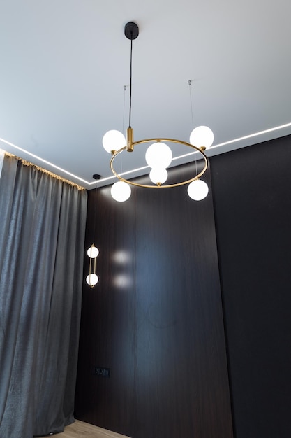 Stijlvolle metalen lampen van gouden kleur aan het plafond in een kamer met een designinterieur