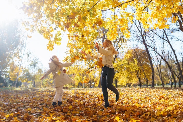 Stijlvolle moeder en dochter genieten van het herfstpark Familie op een wandeling Jeugd loopt rust
