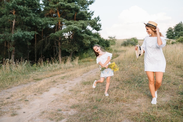 Stijlvolle moeder en knappe dochter met plezier op de natuur