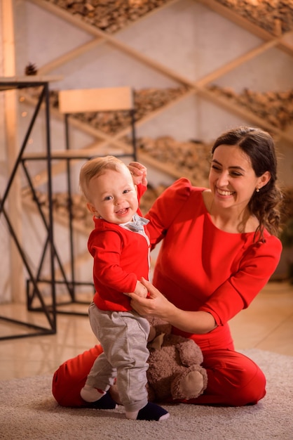 Stijlvolle moeder spelen met babyjongen in de kamer