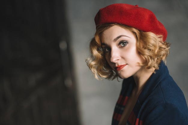 Stijlvolle mooie blonde meisje in een rode baret close-up portret.