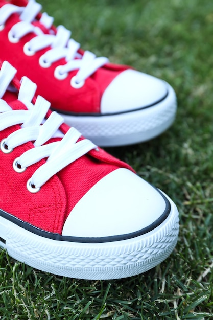 Stijlvolle rode damessneakers op het gras