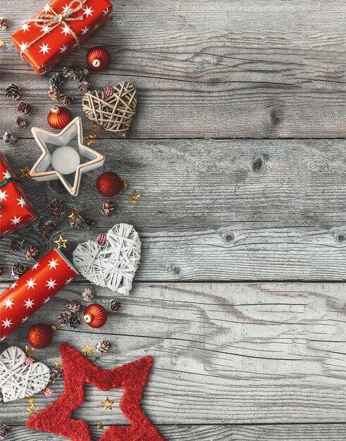 Stijlvolle rustieke kerst woooden achtergrond met rode geschenkdozen, dennenappels en nieuwjaarsdecoratie. plat leggen, ruimte voor tekst.