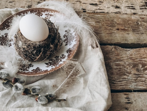 Stijlvolle rustieke paastafel Natuurlijk ei in nest veren vintage bord servet wilg