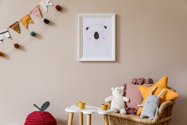 Stijlvolle scandinavische kinderkamer met mock-up poster, speelgoed, teddybeer, pluche dier, natuurlijke poef en kinderaccessoires. Modern interieur met beige muren als achtergrond. Sjabloon. Ontwerp huis enscenering.