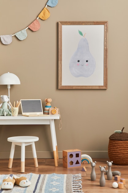 Stijlvolle Scandinavische pasgeboren babykamer met bruin houten mock-up posterframe, speelgoed, pluche dieren en kinderaccessoires. Gezellige decoratie en katoenen vlaggen aan de beige muur hangen. Sjabloon.