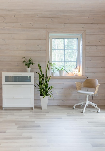 Stijlvolle Scandinavische woon- of slaapkamer met designmeubels planten dressoir en stoel Houten lichte afwerking van wanden en vloer