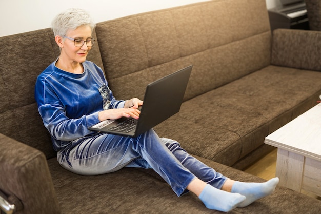 Stijlvolle stijlvolle vrouw met kort kapsel met laptop thuis