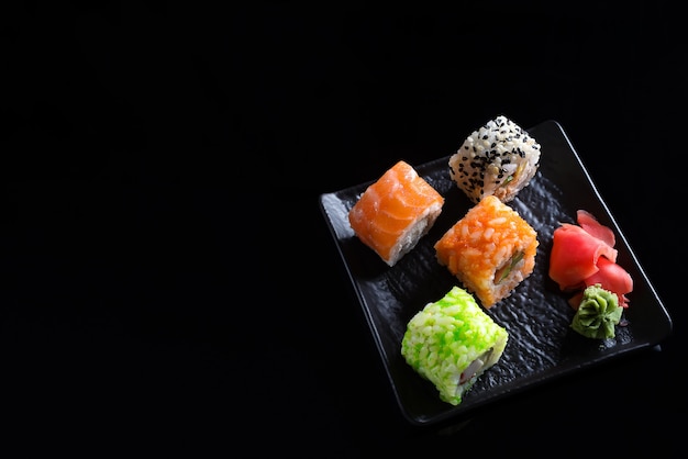 Stijlvolle sushi sets op een zwarte keramische plaat en Chinese sticks.