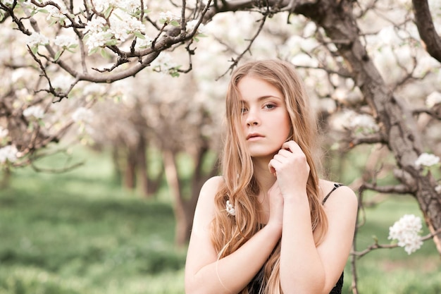 Stijlvolle tienermeisje poseren in appelboomgaard