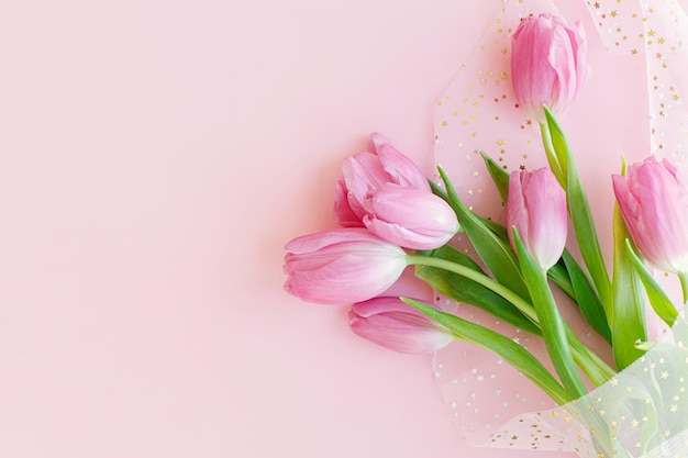 Stijlvolle tulpen boeket plat lag op roze achtergrond Floral wenskaart sjabloon ruimte voor tekst