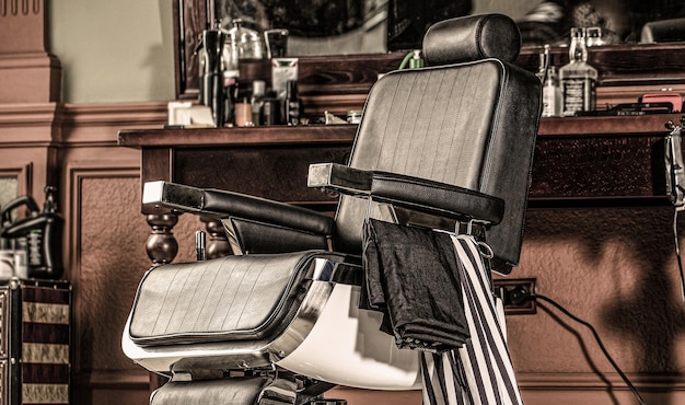 Stijlvolle vintage kappersstoel. Professionele kapper in kapperszaak interieur. Kapperszaak stoel.
