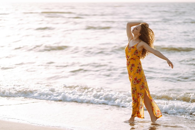 Stijlvolle vrouw in elegante jurk poseren in de buurt van de zee Zomertijd Reisweekend ontspannen