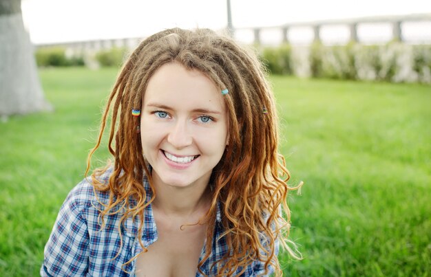 Stijlvolle vrouw met dreadlocks buitenshuis