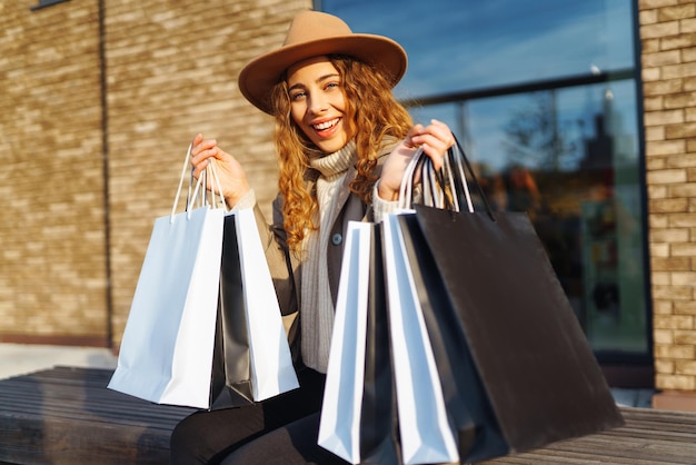 Stijlvolle vrouw na het winkelen op de stadsstraat Koop Black Friday kortingen verkoopconcept