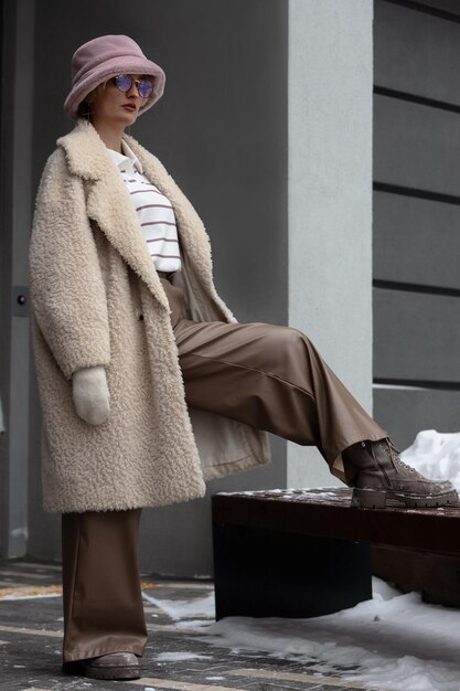 Stijlvolle vrouw poseert in de straat in de winter
