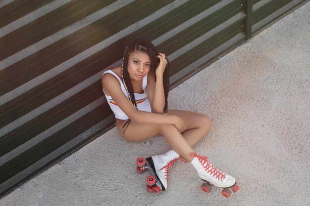 Stijlvolle vrouw zittend op skateboard