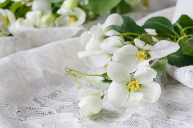 Stijlvolle vrouwelijke ruimte met witte bloemen van appelboom in vaas. Gestileerd minimalistisch stilleven