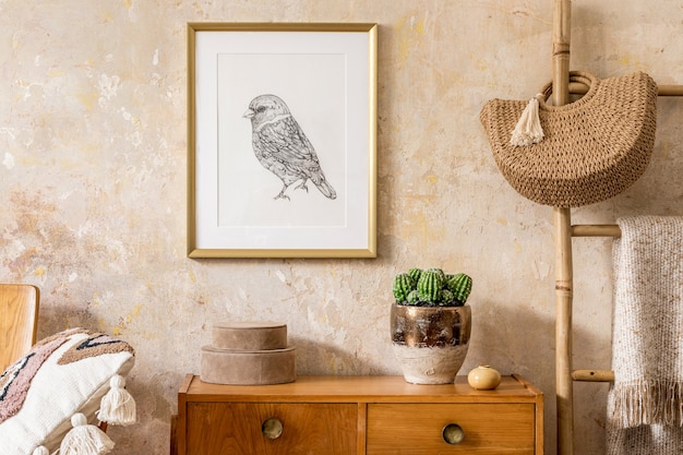 Stijlvolle woonkamer met vintage commode, gouden mock-up fotolijst, houten ladder, tas, plaid, decoratie, grunge muur en elegante persoonlijke accessoires in modern retro interieur.