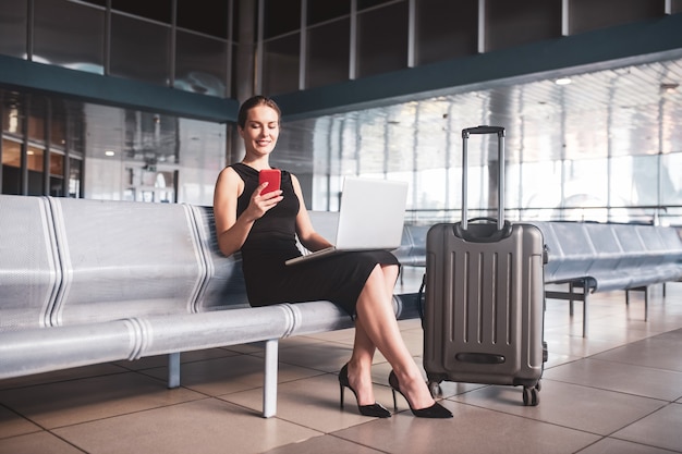 Stijlvolle zakenvrouw met bagage op de luchthaven