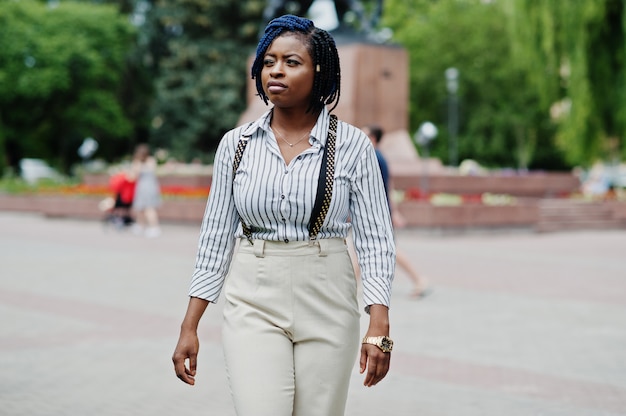 Stijlvolle zakenvrouw op broek met jarretel en blouse poseren buiten