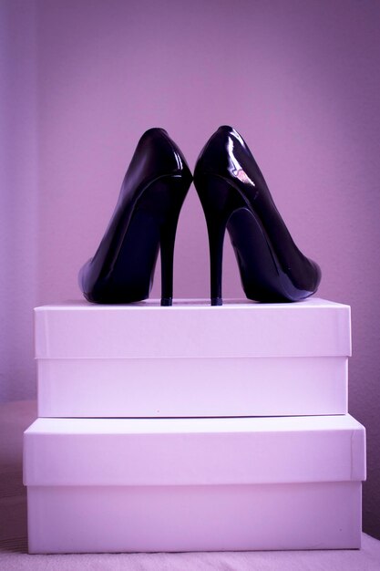 Stilettos on boxes against purple background