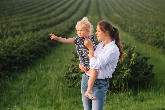 Stilish mother and daughter having fun on the nature