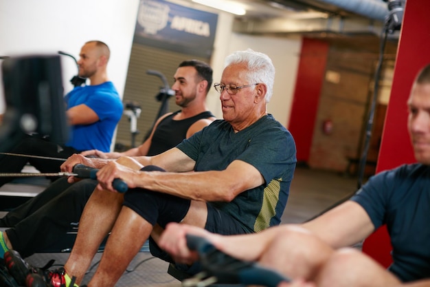 Still keeping pace with the youngsters Cropped shot of a group of men working out on the rowing machine at the gym