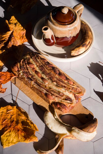 Still life banana pie with a ceramic teapot in the rays of the autumn sun