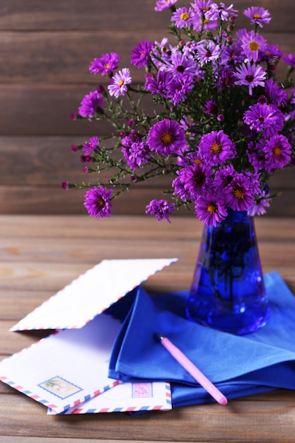 Photo still life of beautiful flowers in vase on wooden background