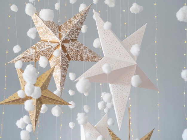 写真 明るい灰色の背景に3d星とふわふわの綿の雲と静物クリスマススタジオの背景。キッズルームの装飾。