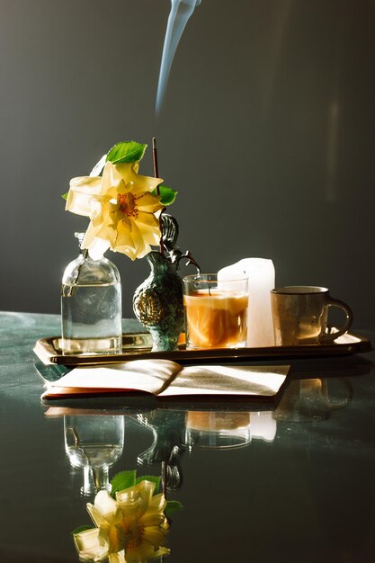 Photo still life coffee cup blooming yellow rosebud rose flower in vase in spring fragrance sticks smoke