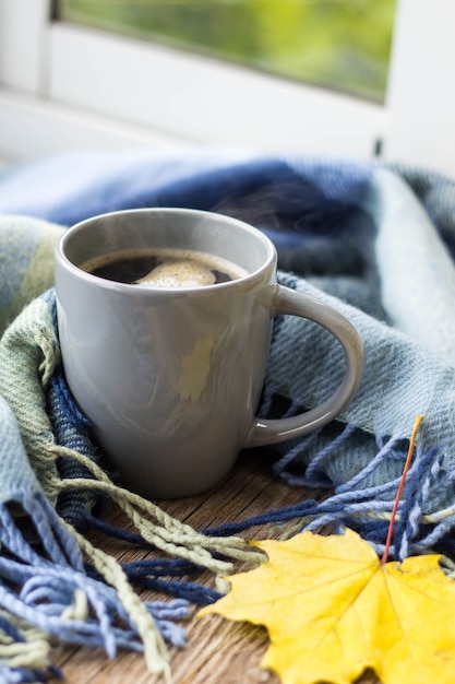 Still life a cup of coffee and autumn leaves with plaid