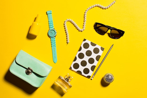 Still life of fashion woman, objects on yellow table